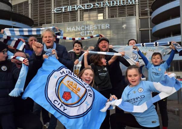 Manchester City fans celebrate at the Etihad Stadium after their team is confirmed as having won the Premier League title following Manchester United's home loss to West Brom on Sunday. Picture: Anthony Devlin/PA.