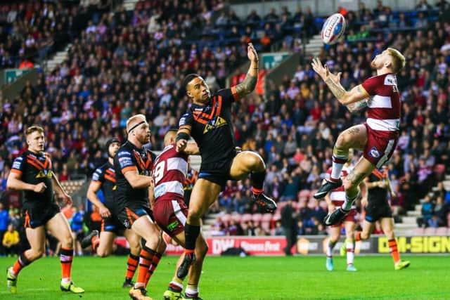 Wigan's Sam Tomkins catches the ball ahead of Castleford's Ben Roberts.