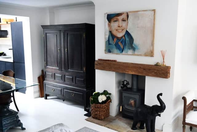 The 1930s painting above the fireplace is a favourite of Chloe's. The antique oak cabinet is usedfor storing crockery and the dining table is an old French  enamelled stove with a glass top.