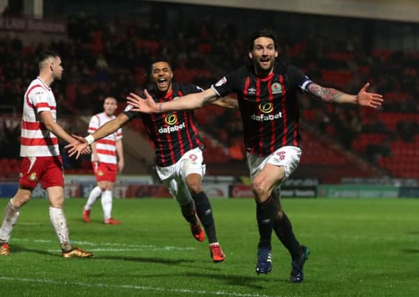 Going up: Blackburn Rovers' Charlie Mulgrew celebrates scoring as Doncaster players troop dejectedly away.