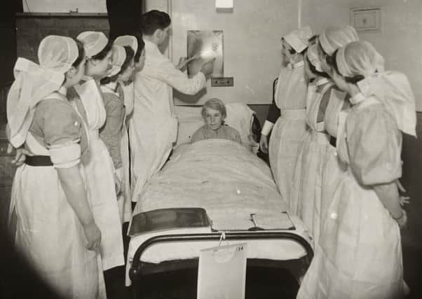 Student nurses around a patient's bed, whilst a doctor explains an X-ray image, at St James' Hospital, Beckett Street, Leeds

in 1941