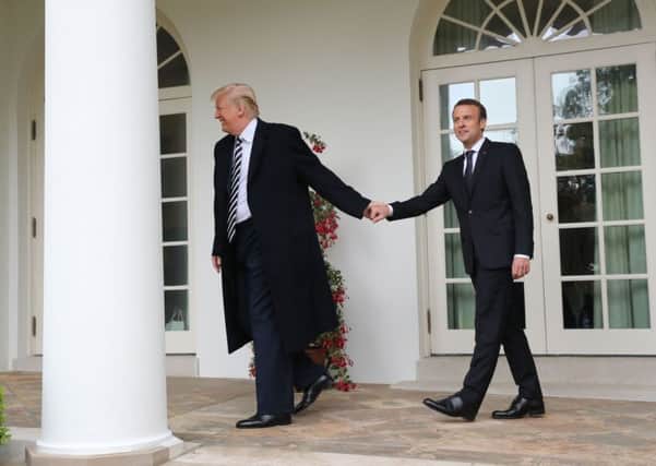 President Donald Trump and French President Emmanuel Macron walk to the Oval Office of the White House in Washington.