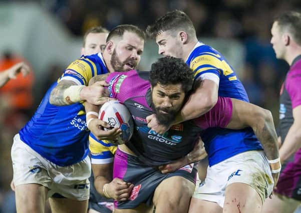Hull KR's Mose Masoe is tackled by Leeds's Adam Cuthbertson and Stevie Ward at Elland Road.