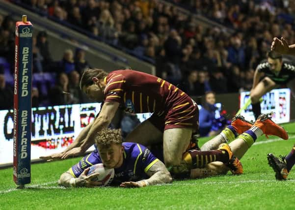 Warrington Wolves' Josh Charnley is tackled by Huddersfield Giants Jake Mamo  as he get over the line for a try.