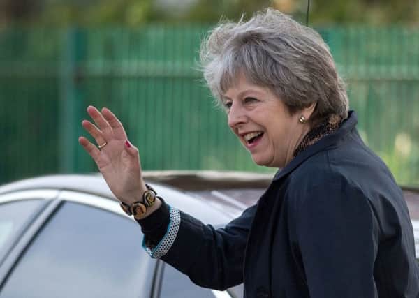 DEFENDING TARGETS: Prime Minister Theresa May waves as she leaves after visiting Brooklands Primary School in Sale, near Manchester, yesterday.