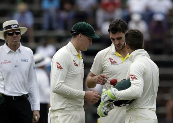 Australia's bowler Pat Cummins, second right, with teammates Matt Renshaw, left, and captain Tim Paine, right, inspect the ball during the fourth Test against South Africa in Johannesburg. Picture: AP/Themba Hadebe