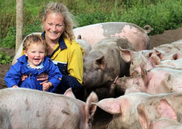 Anna Longthorp with son Richard and some of their pigs.