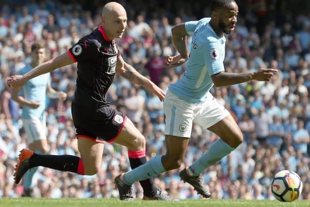 Manchester City's Raheem Sterling (right) and Huddersfield Town's Aaron Mooy battle for the ball at the Etihad Stadium. Picture: Martin Rickett/PA