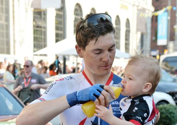 End of the tour: Ben Swift gives his son a drink at the finish.