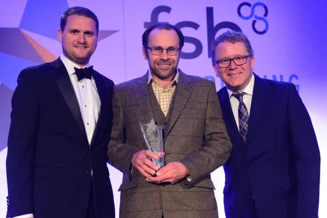 Robert Rose of Rosewood Farm (centre) receives the Ethical and Green Business of the Year Award from the Federation of Small Businesses from Ryan Etchells, head of SME at The Co-operative Bank (left) and host Jon Culshaw.
