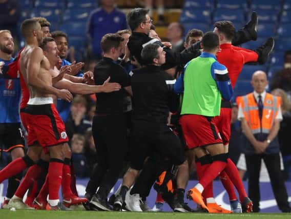 MAGIC NIGHT: David Wagner is hoisted aloft by his Huddersfield Town players after ensuring Premier League survival with a 1-1 draw at Stamford Bridge against Chelsea. Picture: PA.