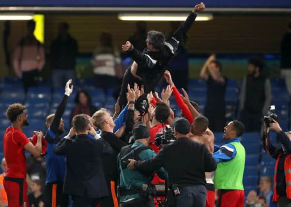 Staying up: Huddersfield Town players lift manager David Wagner in the air as they celebrate.