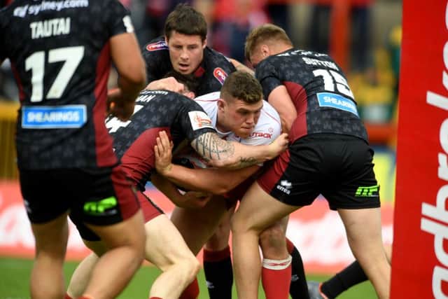 Robbie Mulhern, of Hull Kingston Rovers, has no way to run after he is tackled by Wigan Warrior players.