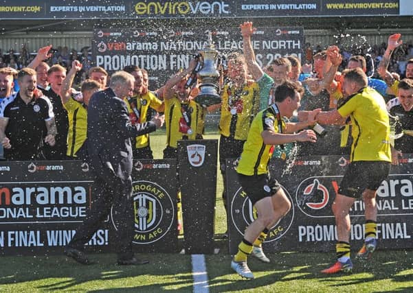 Champagne is sprayed around as Harrogate Town hoist the National League North play-off trophy and get their promotion party underway (Picture: Tony Johnson).