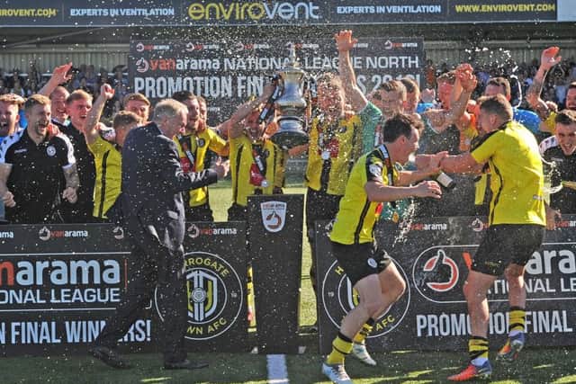 Champagne is sprayed around as Harrogate Town hoist the National League North play-off trophy and get their promotion party underway (Picture: Tony Johnson).