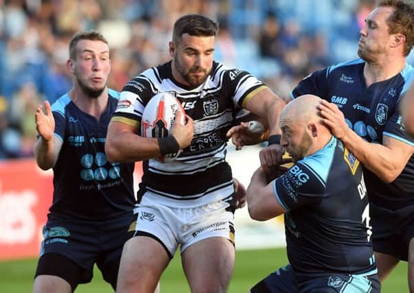 Hull's Josh Bowden is tackled by Featherstone's Josh Hardcastle and John Davies.