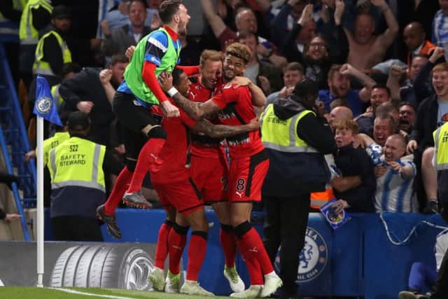 Huddersfield Town's Laurent Depoitre (centre) celebrates scoring his side's first goal of the game with team-mates during the Premier League match at Stamford Bridge, London. Photo: John Walton/PA Wire.