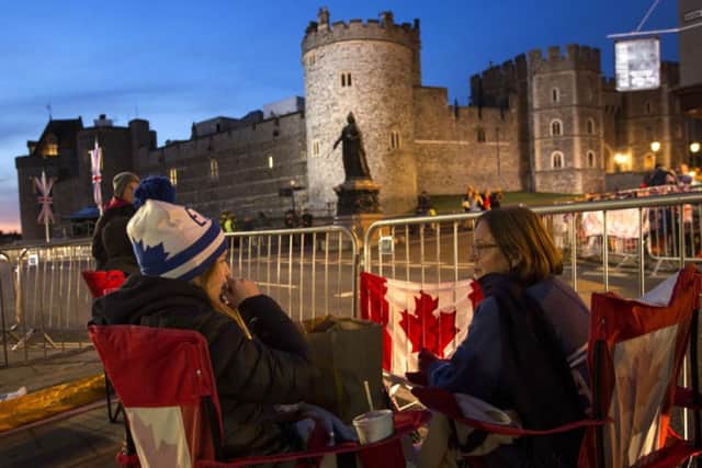 A group of woman from Canada sit outside Windsor Castle.