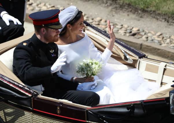 Prince Harry and Meghan Markle ride in an open-topped carriage through Windsor Castle after their wedding in St George's Chapel. PIC: PA