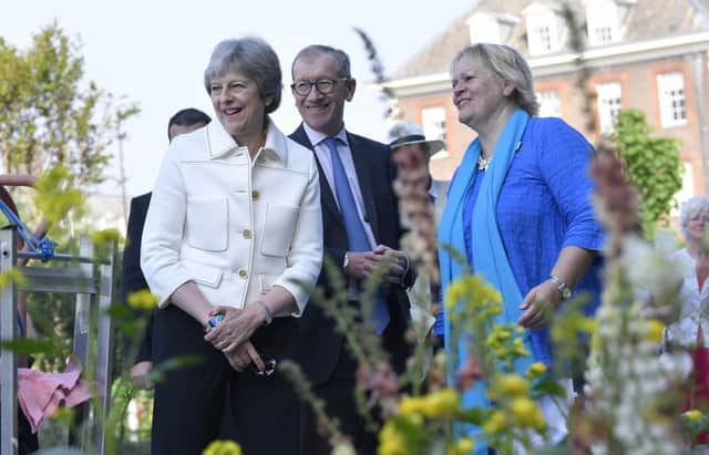 Theresa May, accompanied by her husband Philip, during the press day for this year's RHS Chelsea Flower Show