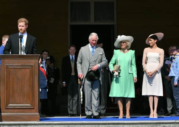 The Prince of Wales, the Duchess of Cornwall and the Duchess of Sussex, listen as the Duke of Sussex speaks during a garden party at Buckingham Palace in London, which the newlyweds are attending as their first royal engagement as a married couple.