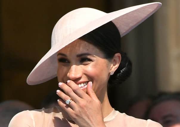 The new Duchess of Sussex at a Buckingham Palace garden party, her first public appearance since her wedding to Prince Harry.