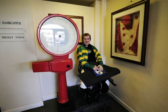 Twenty times jump jockey Sir AP McCoy on the old weighing room scales at Catterick racecourse.