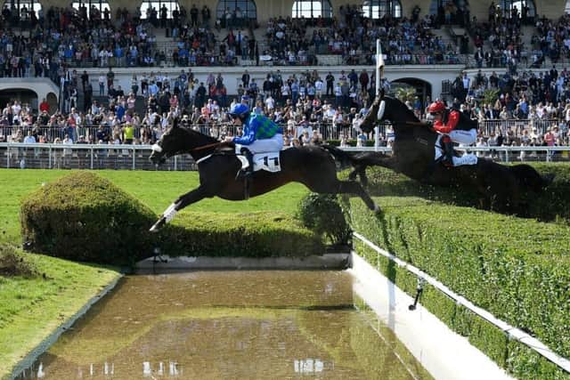 British jockey James Reveley and On The Go jump the Fontaine des tribunes obstacle on their way to winning the Grand Steeple-Chase de Paris at the Hippodrome d'Auteuil in Paris. Picture: Lionel Bonaventure/AFP/Getty Images