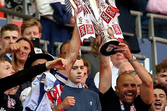 Rotherham United manager Paul Warne lifts the trophy with Richard Wood after winning the Sky Bet League One Final at Wembley Stadium, London. (Picture: PA)