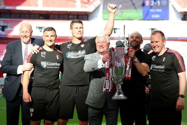 Rotherham United manager Paul Warne (second right) and chairman Tony Stewart (centre right) celebrate with the trophy and first team/development coach Matt Hamshaw (right), goalkeeping coach Mike Pollitt (centre left) and assistant manager Richie Barker (second left) (Picture: PA)