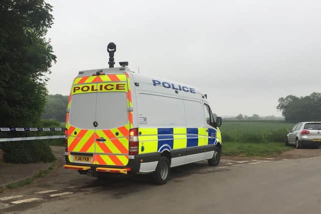 Police near the scene in Aldborough, Boroughbridge where a helicopter crashed in a field. PA photo