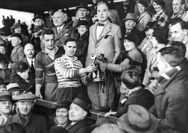 Otley win Yorkshire R. U. Cup in 1936.

T. M. Bentley, the Otley captain, presented with the trophy by Miss Haley, daughter of the President of the Yorkshire Rugby Union after Otley beat Harrogate Old Boys in the final for the Yorkshire Rugby Union Challenge Cup at Lidget Green, Bradford.